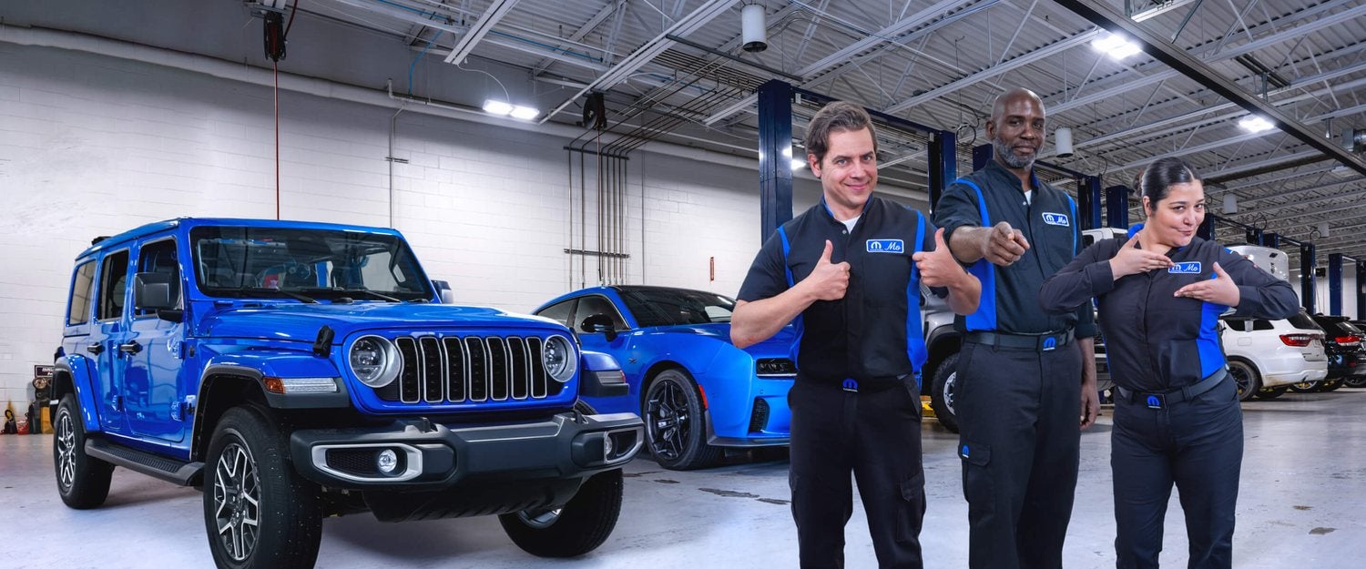 Technicians servicing a Wrangler in the service bay at Holiday CDJR in Graham, Texas