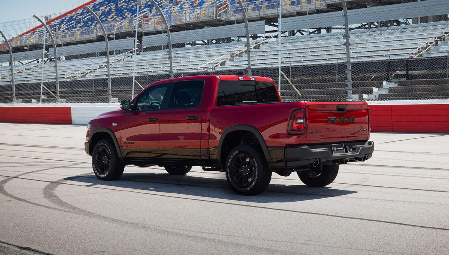 Red 2026 Ram 1500 Rebel 4x4 crew cab seen from the rear driver side angle