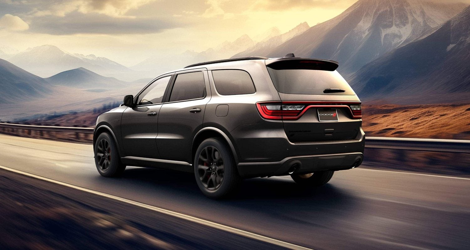 Dark gray 2026 Dodge Durango R/T 392 driving down a highway at sunset