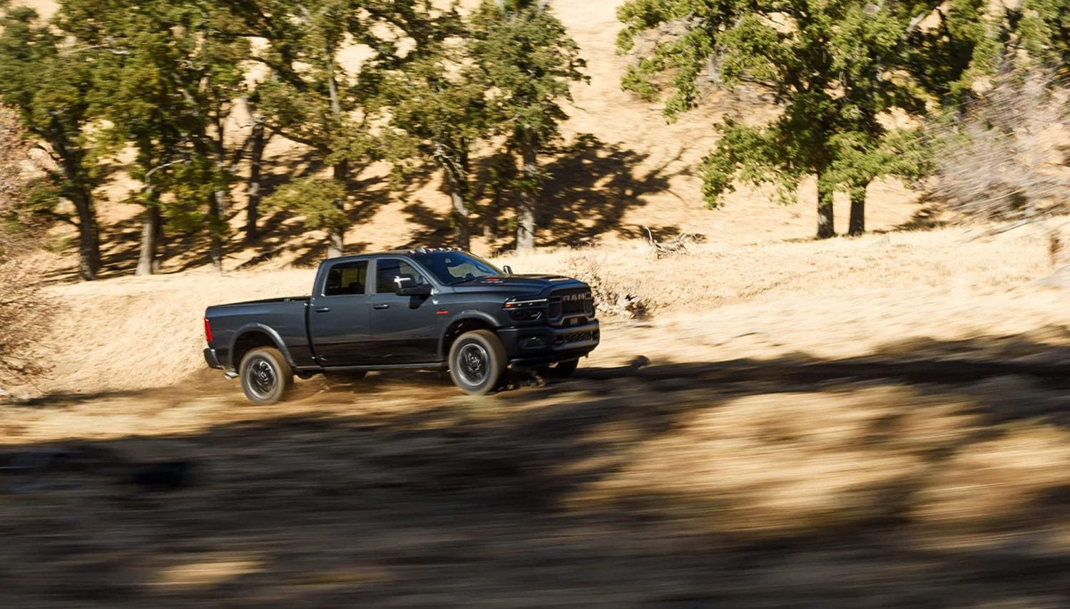 Dark gray 2026 Ram 2500 Rebel heavy duty truck traveling off road in the desert