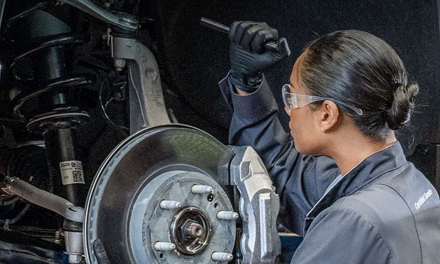 Technician inspecting a wheel and brake assembly in Graham, Texas